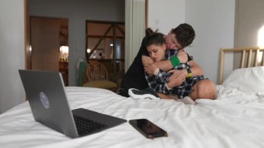 İki yetişkinin bir yatakta samimi bir an paylaştığı, rahatlık ve bağlılık gösteren samimi bir sahne..