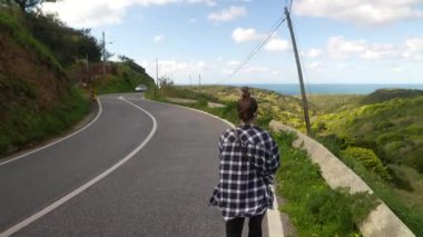 Yeşil tepeler ve çarpıcı bir okyanus manzarasıyla çevrili güzel, dolambaçlı bir yol boyunca harika sakin bir yürüyüş.