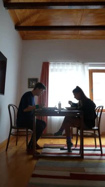 Güzel ve huzurlu bir yemek atmosferini yakalamak, iki bireyin hafif ışıkta yemeğin keyfini çıkarması.