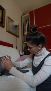 Konforlu bir ev ortamında dizüstü bilgisayarda çalışan odaklanmış bir birey modern teknoloji etkileşimini sergiliyor..