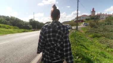 Bir insan, doğa ve mimarinin resimli bir arkaplanı eşliğinde yol boyunca rahatça dolaşır.