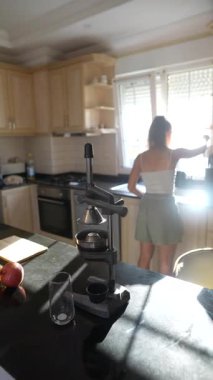 Parlak ve modern bir mutfak alanında genç bir kadın ustalıkla bir dizi taze meyve malzemesi hazırlıyor.