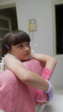 Pembe eldivenli bir kız zihnini dinlendiriyor. Sıcak, rahat ve sade bir ortamda canlı bir hayal dünyasında kayboluyor.
