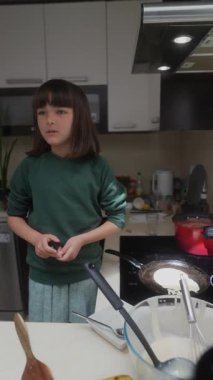 Genç bir çocuk, mutfakta yemek pişirmeye, etkileyici beceriler sergilemeye ve sınırsız yaratıcılık göstermeye hevesli.
