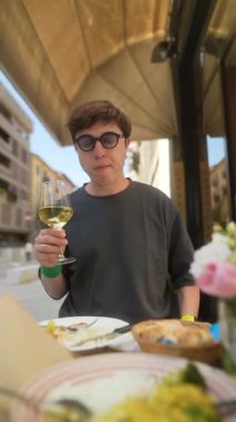 Güneşli bir günde şık bir kafede bir bardak şarabın tadını çıkarıyorum.