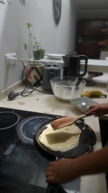 Yetenekli bir çocuk lezzetli krepleri ustalıkla hazırlar. Mutfakta sıcak ve davetkar bir ortam yaratır.