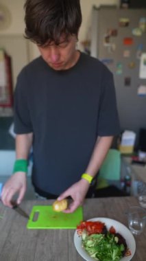 Bir insan mutfakta taze sebzeler hazırlar, sağlıklı pişirme ve yemek hazırlama yöntemlerini somutlaştırır..