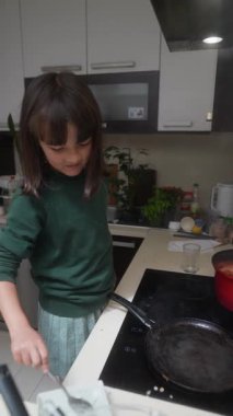 Bir çocuk, anne babasıyla yemek pişirirken değerli mutfak becerilerini ve lezzetli tatları öğrenir.