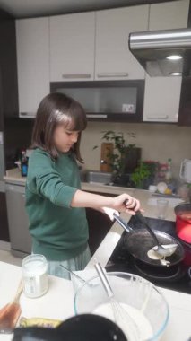 Büyüleyici bir mutfakta, genç bir çocuk ustalıkla krep yapar, etkileyici bir aşçılık yeteneği sergiler.