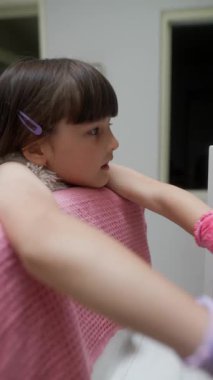 Genç bir çocuk parlak eldivenler giyerken, yaratıcılığını ve eğlencesini gösterirken renkli nesnelerle şakalaşıyor.