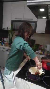 Genç bir çocuk, mutfakta yemek pişirmekten zevk alır. Mutlulukla hamuru karıştırır ve çeşitli yeni aşçılık becerileri öğrenir.