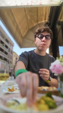 Açık havada leziz yemeklerden hoşlanan bir insan, parlak, güneşli bir ortamda, görsel olarak çekici yemeklerle çevrili.