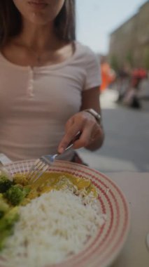 Lezzetli brokoli ve kabarık pirinçten hoşlanan bir kadın sağlıklı beslenme ve yaşam tarzı seçimlerini destekliyor.