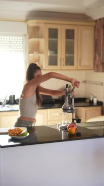 Parlak ve şık bir mutfakta, genç bir kadın hevesle taze meyve sularını özenle hazırlar.