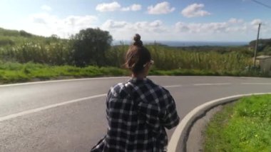 Şık, kareli gömlekli bir kadın manzara yürüyüşü sırasında telefonuyla çarpıcı manzaralar yakalar.