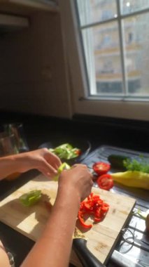 Parlak bir mutfakta renkli sebzeler dilimlemek, yenilikçi mutfak yaratıcılığı ve becerileri sergilemek.