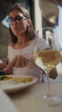 Canlı bir açık hava yemek atmosferinde taze bir bardak beyaz şarapla eşleştirilmiş lezzetli bir gurme salatasının tadını çıkarıyorum.