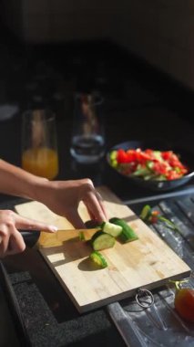 Parlak bir mutfakta, bir kadın taze sebzeleri ustalıkla doğruyor, sağlıklı ve lezzetli yemek yapma sanatını sergiliyor.