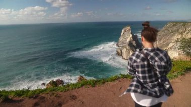 Bir insan nefes kesici bir okyanus manzarasının keyfini çıkararak resime yakın bir yerde uzun süreli anılar yakalıyor.
