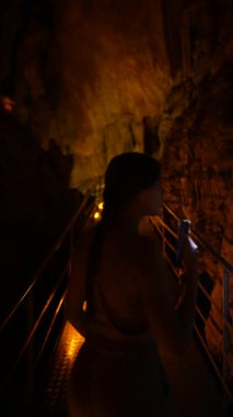 Zeki bir telefonla aydınlanan meraklı bir insan gizemli karanlık mağara geçitlerini cesurca keşfediyor.