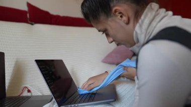 Bir kişi en iyi performansı sağlamak ve hijyeni korumak için dizüstü bilgisayarını özenle ve dikkatlice temizler.