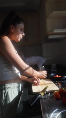 Bir kadın, güneşli bir mutfakta taze malzemeler hazırlar. Mutfak becerileri ve sağlıklı yaşam becerileri sergiler..