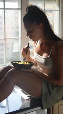 Huzurlu ve huzurlu bir an yaşanıyor. Bir kadın evinde taze bir salatanın tadını çıkarırken.