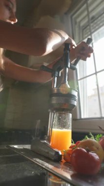 Parlak ve ferahlatıcı bir meyve suyu hazırlama sahnesi. Güneşli bir mutfak ortamında narenciye kullanılıyor.