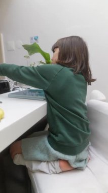 Genç bir çocuk tablet üzerinde dijital yaratıcılığı neşeyle keşfediyor, canlı bir hayal gücü ve bağlılık sergiliyor