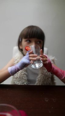 Genç bir kız, rahatlamış bir atmosferde yaratıcılığını ve eğlencesini gösteren bir içkiyle neşe içinde etkileşime girer..