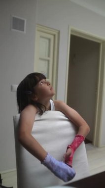 Neşeli genç bir kız neşe ve yaratıcılığını sergileyerek renkli eldivenleriyle evde poz veriyor.