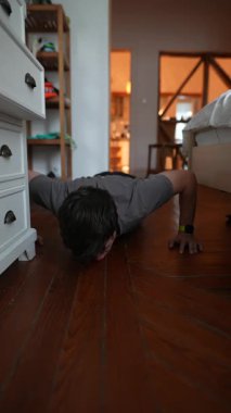 Kapalı mekanlarda şınav çeken kendini adamış bir birey şık bir şekilde tasarlanmış bir odada zindelik ve bağlılık gösteriyor.