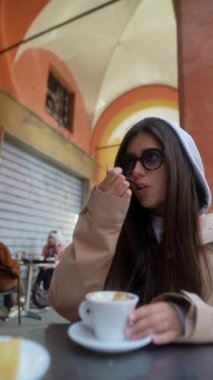 Sıcak bir kafein atmosferinde kahvenin tadını çıkaran şık bir insan yanında lezzetli hamur işleriyle birlikte.