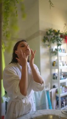 Bir kadın güzel, şık ve rahat bir banyoda sabahları cilt bakımından zevk alır.