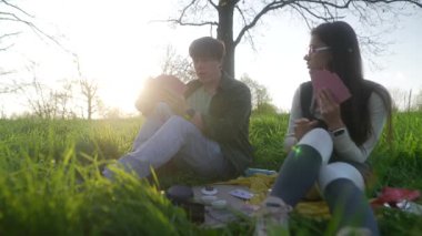 Bir çift, güzel doğayla çevrili sıcak güneşin altında rahatlatıcı ve keyifli bir piknik anının tadını çıkarıyor.
