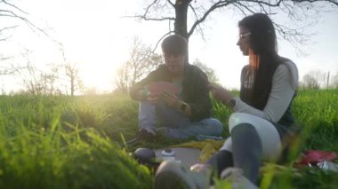 Genç bir çift, birlikte güzel bir gün batımının tadını çıkarır. Lezzetli yemekleri ve doğada birbirlerine eşlik ederler.