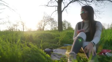 Canlı yemyeşil çimenler ve sıcak güneş ışığıyla çevrili açık havada eğlenen bir insanın güzel, huzurlu bir sahnesi.