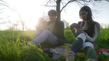 Bir çift güneşin altında pikniğin tadını çıkarıyor, doğayla iç içe ve keyifli bir birlikteliğin tadını çıkarıyorlar.