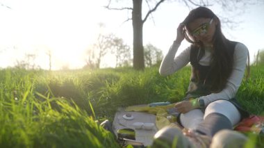 Genç bir sanatçı açık havada neşeyle resim yapar. Yaratıcılık ve güzelliklerle dolu huzurlu bir anı kucaklar.