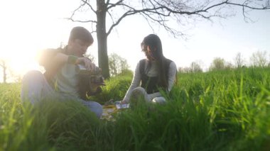 Huzurlu bir an. Güneşin altındaki yemyeşil çimlerin üzerinde güzel bir piknik yapan bir çifti yakalıyorum.
