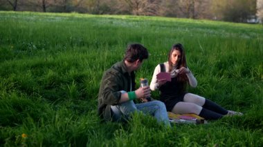 Hoş bir çift, canlı bir yeşillik zeminine karşı huzurlu ve keyifli bir piknik deneyimi yaşıyor.