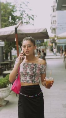 Modaya uygun bir kadın dışarıda telefonla konuşurken stil, şehir hayatı ve gündelik havadan hoşlanır.