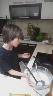 Genç bir çocuk yemek pişirme sürecine hevesle girişiyor, hamuru bir kâsede karıştırıyor ve çeşitli tatları keşfediyor.