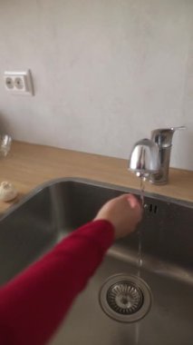 Bir kullanıcı, modern bir musluğun altında el yıkamanın uygun sürecini gösteriyor.
