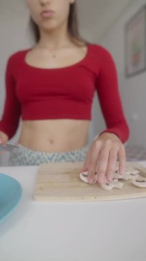 Modern bir mutfakta, genç bir aşçı tutkulu ve canlı malzemeli taze mantarları ustalıkla hazırlıyor.