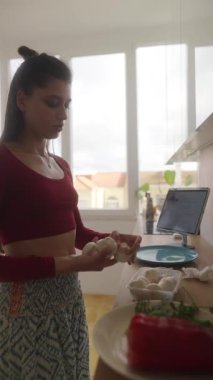 Modern bir mutfak ortamında taze malzemeler kullanan lezzetli yemek hazırlama sürecine katılıyoruz.