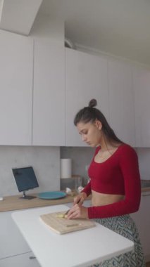 Bir kadın şık mutfağında taze sebzeleri ustalıkla doğruyor. Mutfak ve sağlıklı yemeklerde yaratıcılığı ön plana çıkarıyor.