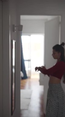 Modayı takip eden genç bir kadın aynanın önünde poz veriyor. Parlak bir iç mekanda zarafet ve tarz sergiliyor..