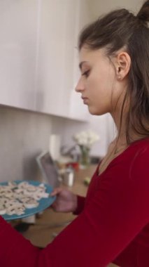 Şık giyinmiş genç bir kadın şık mutfağında dilimlenmiş mantar hazırlıyor.