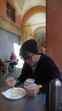 Kahvenin, pastanın ve düşünceli bir bireyin yer aldığı rahat bir kafe sahnesi.